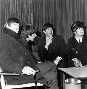 Liverpudlian pop group the Beatles wait for their flight at London Airport.