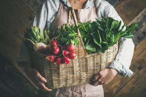 woman holding leafy greens in a basket