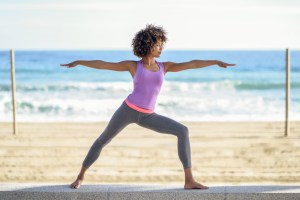 black woman in activewear practicing yoga