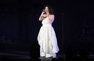 Lorde performing at CBS RADIO's We Can Survive 2017 wearing a white billowing gown.