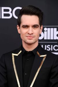 Brendon Urie wearing a black blazer with gold detailing.