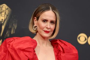 Sarah Paulson smiling wearing a red puff sleeve gown.