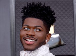 Lil Nas X attends the 64th Annual GRAMMY Awards smiling looking back, Lil Nas X's Most Iconic Fashion Moments Ranked.