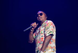 Nas performing on stage wearing shades