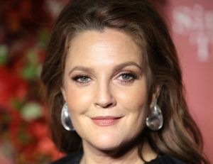 Drew Barrymore - closeup of her face. she's wearing earring and grinning