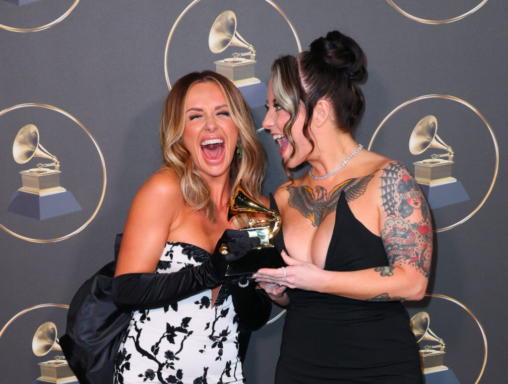 Carly Pearce in a white dress and Ashley McBryde wearing a black dress accepting their 2023 Grammy