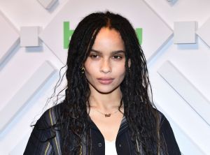 Zoe Kravitz attends 2019 Hulu Upfront smiling looking left wearing a black striped shirt with a white undershirt.