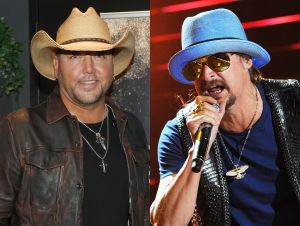 Jason Aldean in a black shirt and jacket and a cowboy hat, Kid Rock in a blue hat and black shirt on stage
