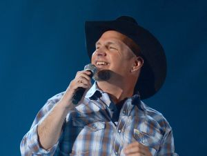 Garth Brooks performing in a plaid shirt and black cowboy hat