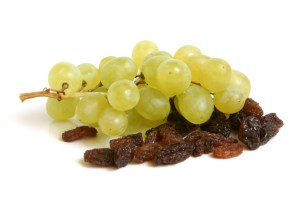 Bunch of grapes and raisins on a white background
