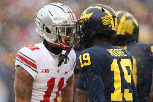 Jaxon Smith-Njigba #11 of the Ohio State Buckeyes and Rod Moore #19 of the Michigan Wolverines talk helmet-to-helmet during the first quarter at Michigan Stadium