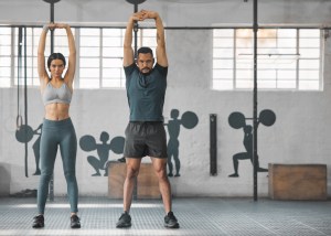 Fitness, active and healthy couple stretching, exercising or training together inside gym. Weight lifting is the most popular workout in New Jersey