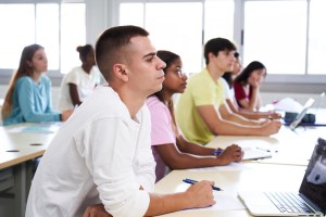 students listening to lecture while attending a class in the classroom.