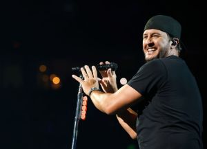 Luke Bryan on stage wearing a backwards baseball cap