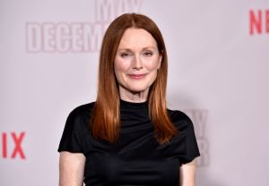 Julianne Moore attends Netflix's "May December" Los Angeles Photo Call smiling wearing a black t-shirt.