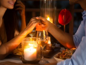 Romantic couple holding hands together over candlelight during romantic dinner, most romantic small town concept.