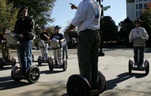 Tourists ride the Segway Human Transporters as they listen to their tour guide during a Segway tour