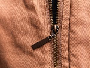 Close up of brown jean jacket zipper