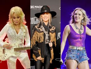 Dolly Parton in a white rhinestone jumpsuit playing guitar, Lainey Wilson in a black jackey=t and hat, and Carrie Underwood on stage in a purple tanktop