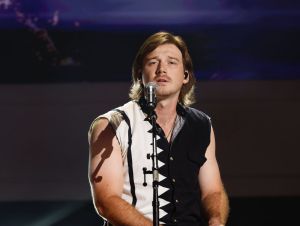 Morgan Wallen on stage wearing a black and white button down shirt