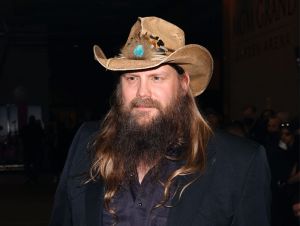 Chris Stapleton dressed in black and a straw cowboy hat backstage at the GRAMMYs