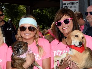 Miranda Lambert and her mom Beverly both wearing sunglasses, pink t-shirts and carrying dogs