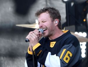 Dierks Bentley performing on an outside stage wearing a black NHL hockey jersey