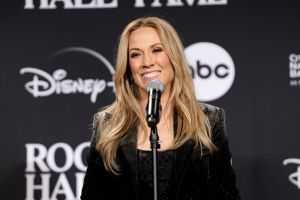 Sheryl Crow speaks in the press room during the 38th Annual Rock & Roll Hall Of Fame Induction Ceremony smiling wearing black.