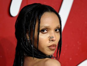 FKA Twigs attends The Fashion Awards 2023 looking back wearing a leaf nose accessory.