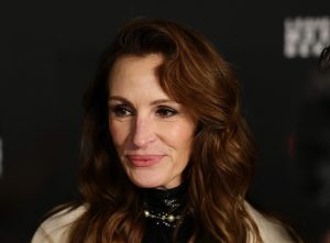 Julia Roberts attends Netflix's "Leave The World Behind" premiere facing left smirking wearing a khaki jacket.