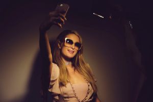 Paris Hilton taking a selfie. There's a new photo trend: the nose cover