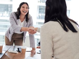 Shot of two businesspeople shaking hands in a meeting at work, new job concept.