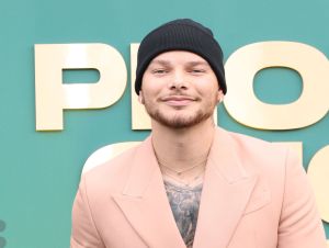 Kane Brown in a black knit hat and a peach blazer.