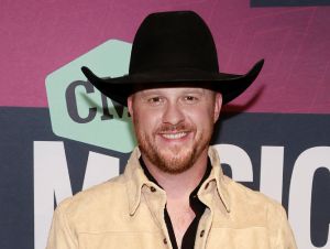 Cody Johnson wearing a black cowboy hat and a tan button down shirt.