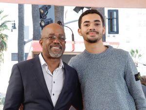 Darius Rucker in a black blazer with his son Jack in a gray sweater.