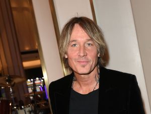 Keith Urban posing in a black shirt and jacket