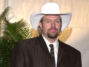 Toby Keith in the 1990s in a brown suit and a white cowboy hat
