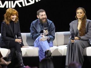 Reba in a black suit, Post Malone in a denim jacket, and Andra Day in a black pin-striped suit at the Super Bowl LVIII press conference.