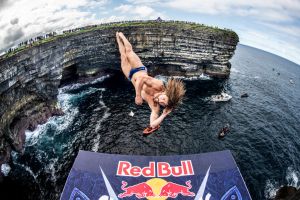 A man jumping off a high cliff as a part of a Red Bull event