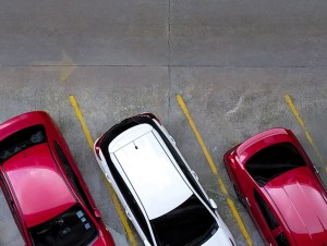 Top view of car parked at concrete car parking lot with yellow line of traffic sign on the street. Above view of car in a row at parking space. No available parking slot. Outside car parking area. - stock photo