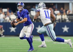 Daniel Jones #8 of the New York Giants looks to throw the ball as he is pressured by Micah Parsons #11 of the Dallas Cowboys