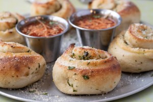 A closeup shot of the tasty garlic knots with ketchup in a plate