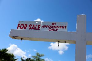 Blue skies with a home for sale sign.