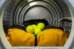 Tennis balls with jacket in tumble dryer to loose down and feathers and not stick together in padding , fluff up laundry, pillows, sheets