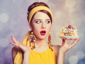 Style redhead girl with cake. Photo with bokeh at background, retro concept