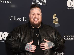 Jelly Roll on the Clive Davis red carpet wearing a black shirt and black leather jacket.