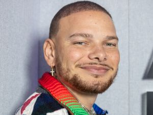 A close-up of Kane Brown's face, and he's wearing a colorful jacket.