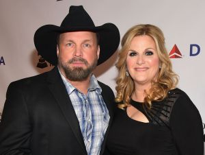 Garth BRooks in a black blazer and cowboy hat, and Trisha Yearwood in a black dress.