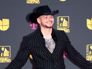 Kane Brown's daughter - Kane on a red carpet wearing a black suit and black cowboy hat.