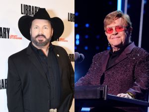 Garth Brooks Paid Tribute To Elton John - Garth is wearing a black blazer and cowboy hat, and Elton John is wearing a purple blazer with sparkles and rose-colored glasses.